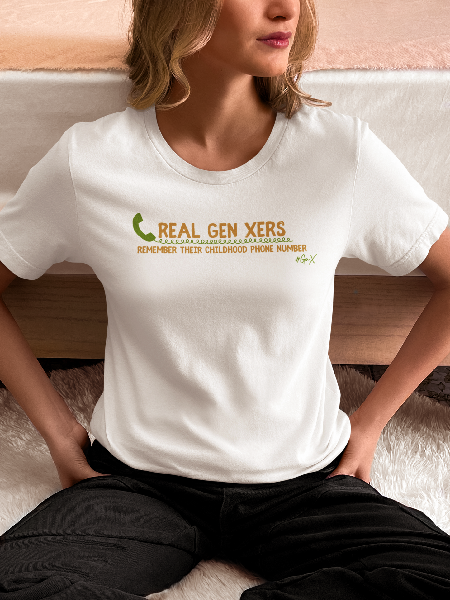 blonde woman sitting by bed wearing white real gen xers remember their childhood phone number shirt 